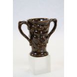 19th century treacle glaze loving cup decorated with two faces of Bacchus