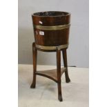 Early 20th century Coopered Oak and Brass Bound Planter raised on three legs united by a shelf,