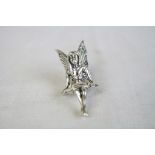 Silver figure of a seated fairy with emerald S set to the wings