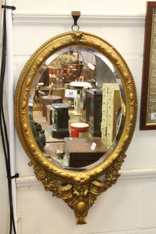 19th century oval Bevelled Glass Mirror with ornate Gilt painted frame & pair of Sconces to base,