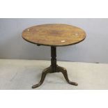 Georgian Oak Circualar Tilt Top Pedestal Table raised on a turned column support and three splayed