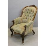 Victorian Button Back Walnut Framed Armchair with floral carving and scrolling arms raised on