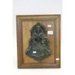 An Oak plaque decorated with an embossed bronze figure of Queen Elizabeth 1st on her throne