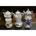 Three ceramic teapots with burner stands