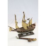 A vintage pipe with carved bird decorated bowl and a model sailing ship on stand