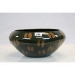 A studio bowl in the style of Poole Pottery, green ground with brown fleck decoration, unmarked
