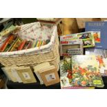 A wicker basket containing a collection of childrens books to include Ladybird and Beatrix Potter.