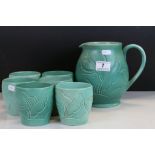 Susie Cooper Earthenware Lemonade jug & six beakers with carved Tulip decoration & matt green glaze,