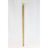 An antique malacca walking stick with carved ivory handle and white metal mount