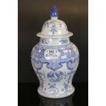 Contemporary blue and white oriental lidded vase with stylized dragon decoration