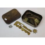 A Small Collection Of Militaria Contained Within A 1942 Dated Military Brass Tin Together With A