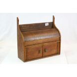 Early 20th century Oak Stationery Cabinet with curved hinged lid above two panel doors