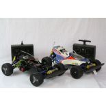 Two Tamiya Thunder Shot electric remote control cars together with two remote controls.