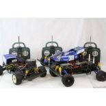 Two Tamiya Terra Scorcher 58075 remote control cars together with a spare rolling chassis and