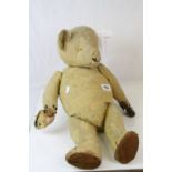 Early 20th C straw filled teddy bear, well loved and with much wear, 23" approx height