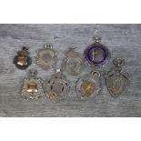 Eight Victorian and later silver fob medallions including double sided parcel gilt fob with blank