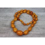 Butterscotch amber graduated oval bead necklace, comprising thrity-five beads, the smallest bead