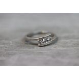 Diamond three stone platinum crossover ring, three small round brilliant cut diamonds, total diamond