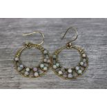 Pair of opal 9ct yellow gold drop earrings, the pierced circular design set with twelve small round