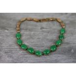 Jadeite unmarked rose gold line bracelet, comprising ten oval cabochon cut green jadeite, dimensions