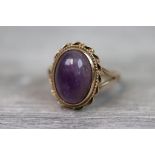 Amethyst 9ct yellow gold ring, the oval cabochon cut amethyst with rub over setting, rope twist