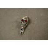 A silver scull whistle with rubilite eyes