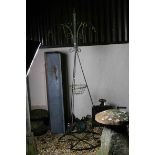 A vintage wrought iron garden obelisk plant stand.