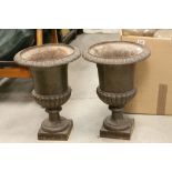 A pair of vintage cast iron urns in the classical style.
