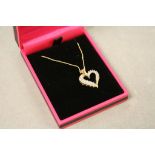 A 14ct yellow gold diamond set heart shaped pendant necklace on gold chain