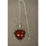 A silver heart shaped amber style pendant necklace on silver chain