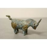 A bronze metal figure of a bull .