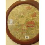 Pair of circular well worked embroidered silk pictures depicting a cluster of flowers, circular