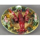 A Palissy style plate, typical colour and decoration featuring a lobster and other fruits of the