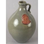 Humphry WAKEFIELD (British 20th/21st Century) A celedon glazed bellamine style jug, the base bearing