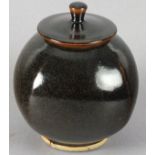Nic HARRISON (British b. 1949) A globular faceted lidded vase, with a speckled dark brown glaze,