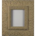 A buff painted wall mirror, with cast leaf decoration, aperture 9.25" x 7.25" (23.5cm x 18.5cm)