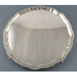 A large circular silver salver, Sheffield 1939, with an ogee shaped edge and raised on pointed pad