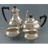 A silver four piece tea/coffee service, Sheffield 1975, of part gadrooned pattern with ebonised