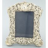 A silver repousse photograph frame, Birmingham 1900, decorated with putto and fruiting vines, 20cm x
