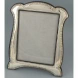 A silver photograph frame, of easel form, the decoration including foliage, Birmingham 1912,