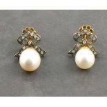 A pair of white pearl drop earrings with diamond bow tops