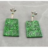 A pair of rectangular shaped patterned jade drop earrings set with emeralds and diamonds