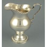 A silver helmet shaped cream jug, London 1960, with leaf capping to handle and gadroon lip and