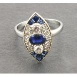 A platinum marquise shaped sapphire and diamond ring, set with a central oval shaped sapphire,