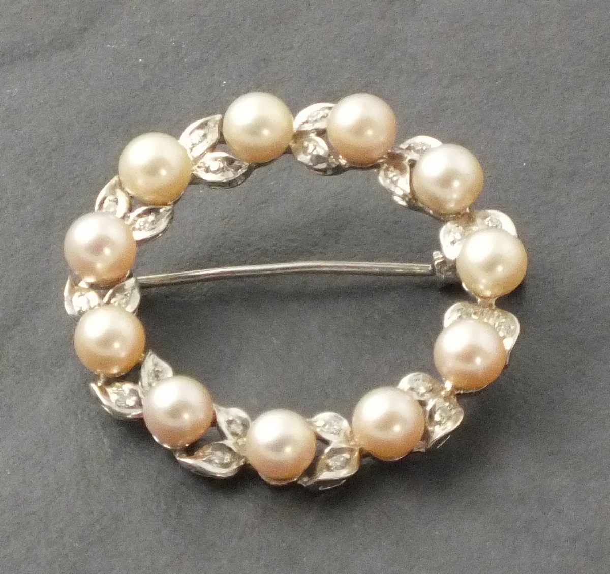 A pearl circular brooch, set in 18ct white gold, 7gms