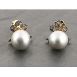 A pair of grey pearl drop earrings set with diamond bow tops