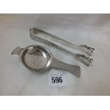 A pair of eastern cake tongs, pierced with figures, also a matching tea strainer 85g.