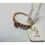 High carat gold narrow band ring set with diamonds and a central ruby approx size N