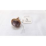 An antique 9ct gold seal with amethyst coloured intaglio