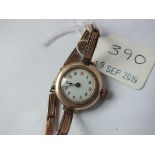 Ladies 9ct. circular faced wrist watch with 9ct. expanding strap